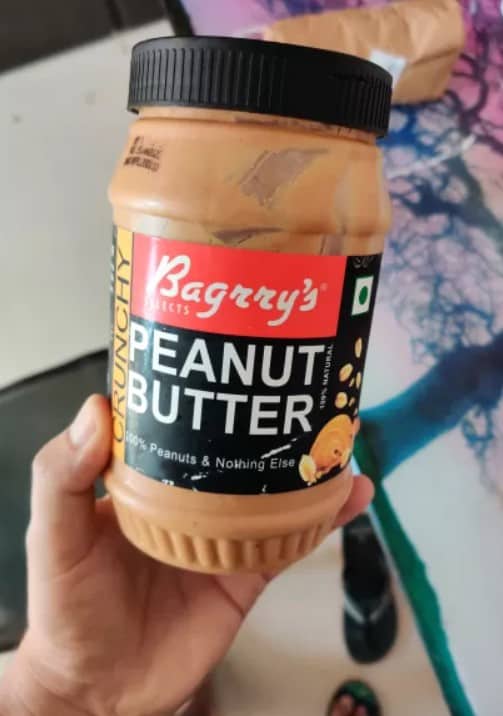 Me Holding a Container of Bagrrys Natural Peanut Butter