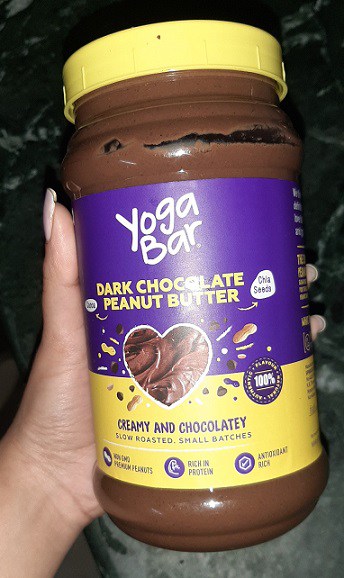 Me Holding a Container of Yogabar Dark Chocolate Peanut Butter